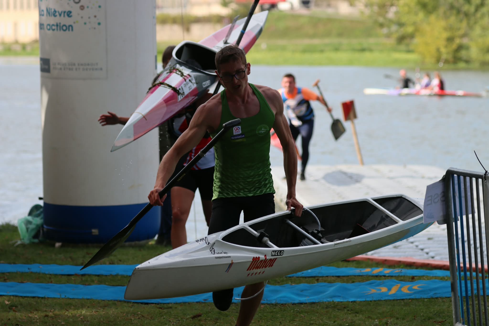 Floryan Courdent carrying his canoe and paddle during a marathon portage